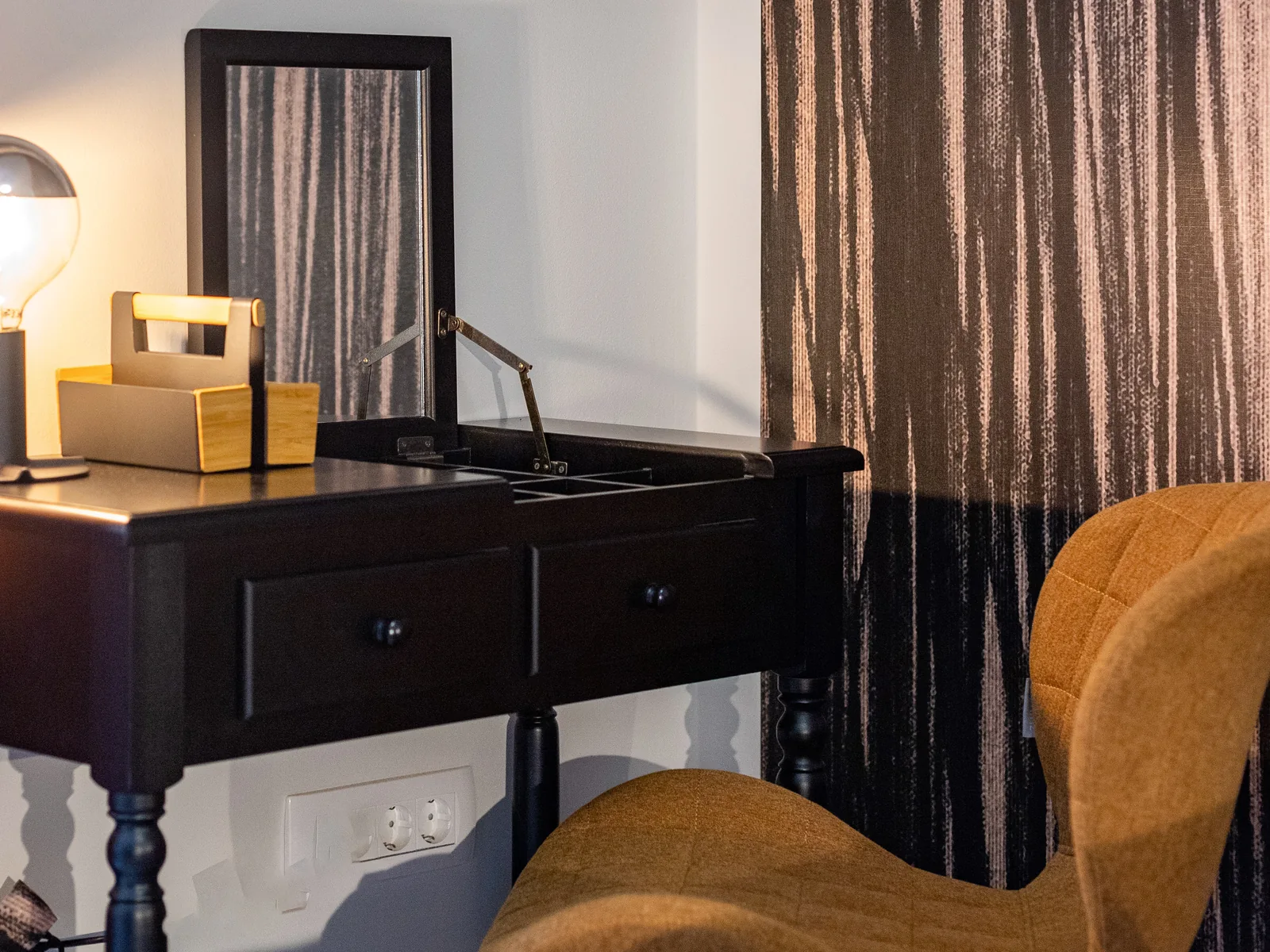 Dressing table with mirror and workspace beside textured curtains