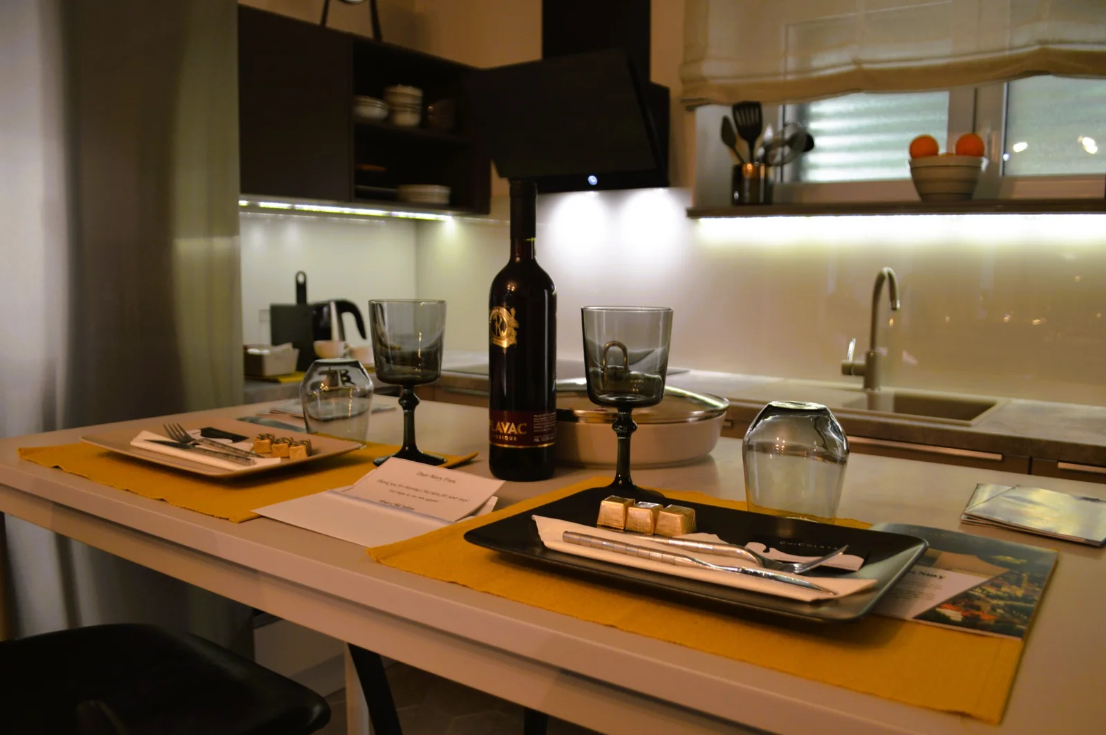 Dining table prepared with local wine and welcome treats in the apartment